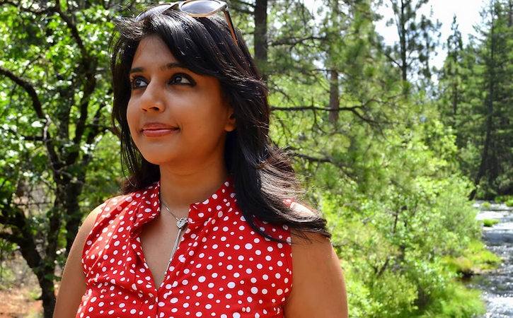 Paromita Sengupta standing in a wooded area next to a river